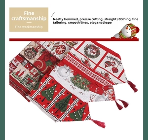 Close-up of Christmas table runner with festive tree patterns and red tassel edges