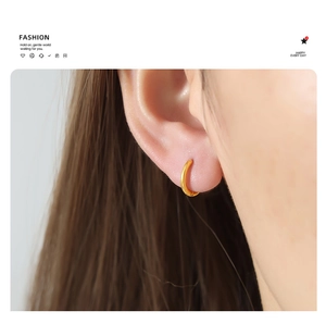 Close-up of minimalist 18K gold plated hoop earrings worn on ear showing high mirror polish