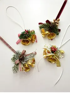 Close-up of golden Christmas bells with pine cones and festive ribbon bows for decor