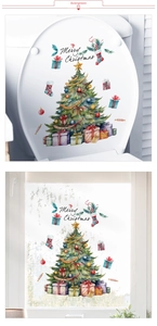 Detail of Merry Christmas stickers with tree and gift boxes on toilet lid and glass window