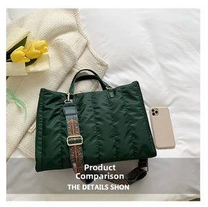 Detail of dark green quilted nylon tote bag featuring ethnic style embroidery wide strap