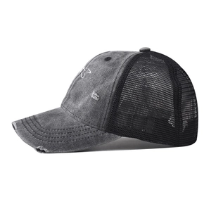 Dettaglio del cappello trucker in stile vintage con ricamo floreale e retro in rete