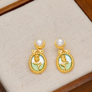 French vintage tulip pearl earrings with gold oval rose pendant on linen background
