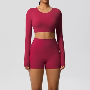 Detail van de high-waist yogashort en crop top met lange mouwen in donkerrode stof