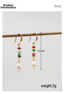 Detailed view of ethnic style gold hook earrings with colorful beads and white drop pearl