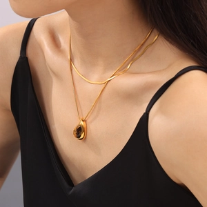 Double-layer 18k gold plated necklace with teardrop tiger eye pendant on a model