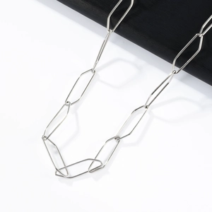Detailed close-up of a silver stainless steel paperclip chain necklace on split background