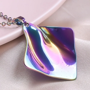 Macro shot of 18k gold plated iridescent wave square pendant on pink silk background