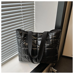 Close-up of black quilted nylon tote bag with glossy finish and square stitch pattern