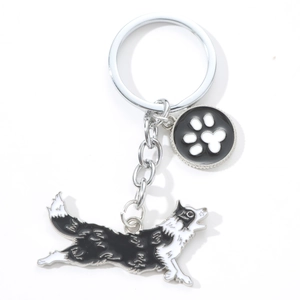 Detail of Border Collie metal keychain with small paw print charm and silver link chain