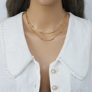 Double-layered gold bead snake chain necklace worn on model for elegant minimalist style