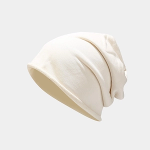 Close-up of beige knitted beanie featuring a rolled edge and soft textured fabric