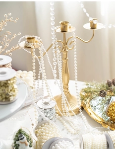 Guirlande de perles blanches décoratives sur un chandelier doré pour projets de DIY
