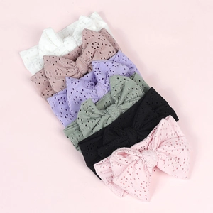 Detail view of hollow lace bow headbands in various colors for babies and infants