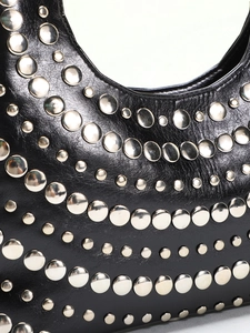 Detailed macro shot of premium black leather with staggered silver rivets on shoulder bag