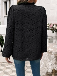 Detailed back view of a black hollow-out embroidered long-sleeve top with puff sleeves