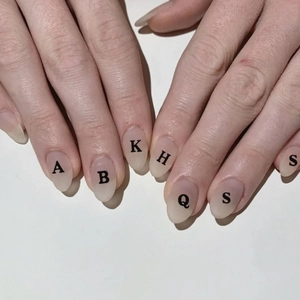 3D laser alphabet nail art stickers with black English letters on nude background