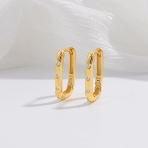 Macro detail of S925 sterling silver gold rectangular hoop earrings with zircon stones