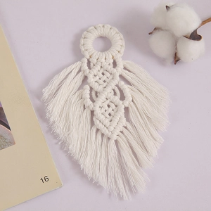 Detail view of a handcrafted white cotton woven leaf wall hanging in bohemian style