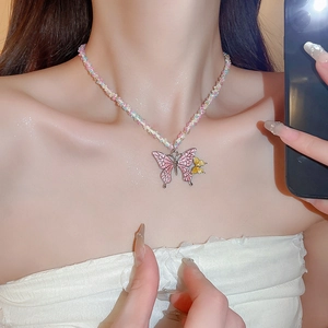 Close-up of a colorful beaded necklace featuring double butterfly pendants on a collarbone
