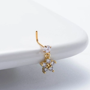 Gold L-shaped nose stud featuring a sparkling floral zircon pendant on a white surface
