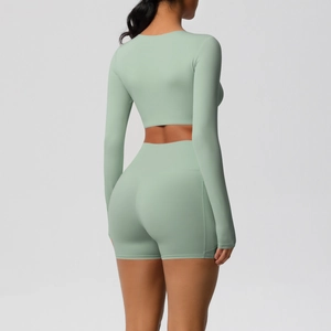 Detail van lichtgroene yoga set met korte broek met hoge taille en crop top met lange mouwen