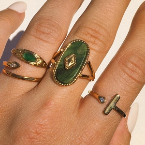 Detailed view of three gold vintage rings set with green stones and blue zircons