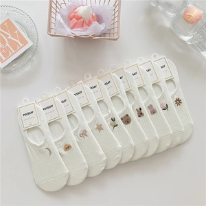 Detail of ten pairs of white cotton no-show socks with diverse cute animal embroidery