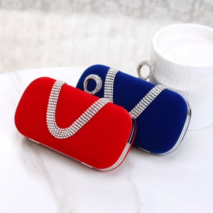 Detail of red and royal blue velvet evening bags with rhinestone tassels on marble
