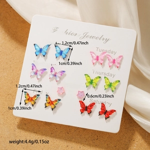Detailed view of butterfly and star earring set with dimensions on daily display card