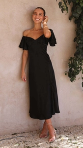 Détail d'une robe longue élégante en satin noir à épaules dénudées et manches à volants