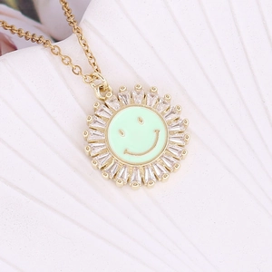 Close-up of sunburst pendant with green enamel smiley face and sparkling cubic zirconia