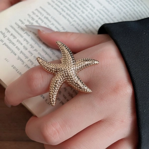 Nahaufnahme des goldenen Seestern-Rings mit detaillierter Metalltextur und Schichtdesign