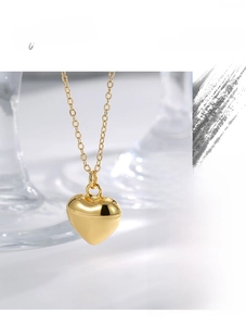 Macro detail of high-quality polished gold heart pendant with fine link chain necklace