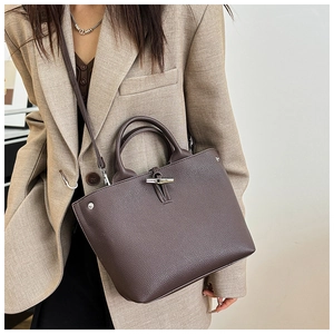 Close-up of brown lychee leather bucket bag with silver bamboo buckle and top handle