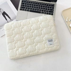 Flat lay of cream white quilted cotton laptop sleeve with cloud texture and metal zipper