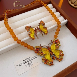 Vintage orange beaded jewelry set with enamel butterfly necklace and matching earrings