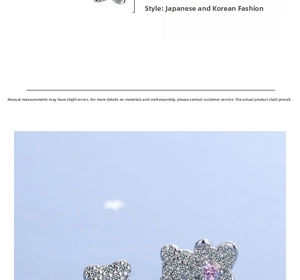 Detailed macro view of silver teddy bear earrings with white and pink cubic zirconia