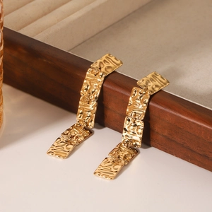 Detailed macro view of 18K gold plated square hammered texture fringe drop earrings