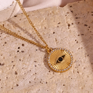 Macro shot of 18K gold plated sunburst pendant with evil eye motif and zircon stones