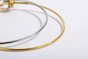 Detail shot of slim stainless steel adjustable bangles in polished gold and silver finishes