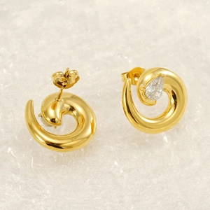 Detail of spiral gold plated earrings featuring pear cut zircon and butterfly back closures