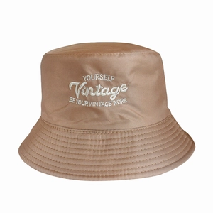 Close-up of khaki bucket hat featuring detailed embroidery and fine fabric texture