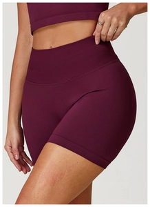 Detail of high-waist seamless burgundy yoga shorts showing ribbed waistband and texture