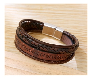 Detailed macro view of brown braided leather strands and silver magnetic clasp on the bracelet