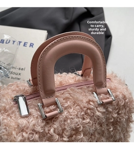 Detail shot of pink fuzzy faux shearling boston bag with silver hardware and leather handles