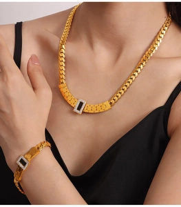 Detail of gold chain set with square black stones and sparkling crystal accents