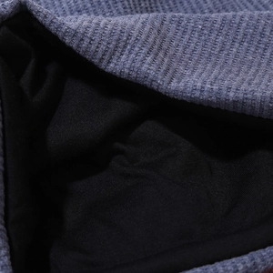Détail du tissu gaufré bleu et de la doublure intérieure noire lisse du bonnet unisexe