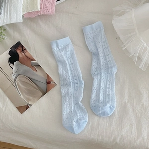 Close-up of light blue hollow knit mesh socks with floral patterns and ribbed cuffs