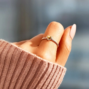Minimalist s925 sterling silver ring with a golden heart worn on a finger